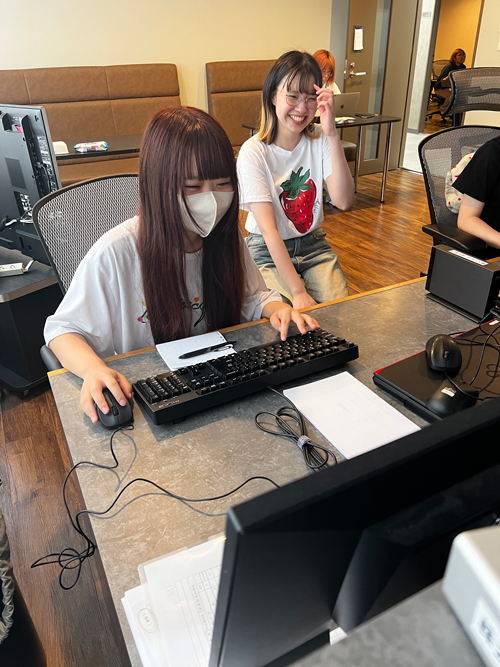 先輩の指導を受けながら件数を受ける新人