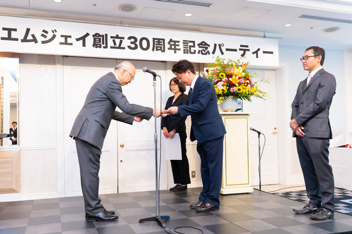 表彰式で森田社長から賞状を受け取る北澤副社長