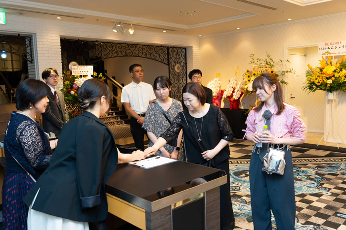 会場に到着するエムジェイ従業員の家族