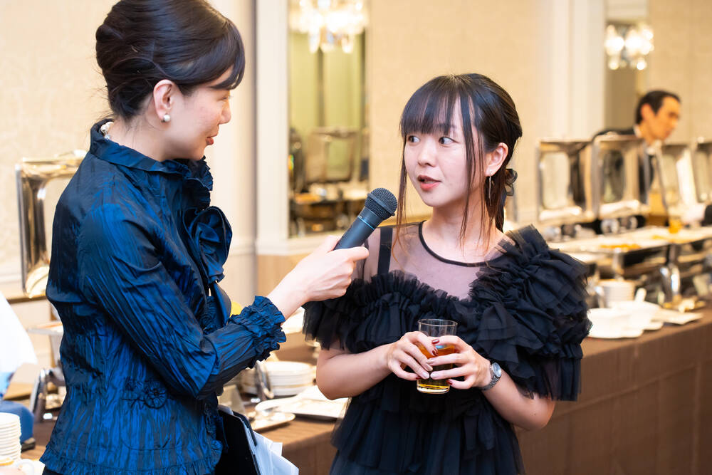 司会者のインタビューに答える社員