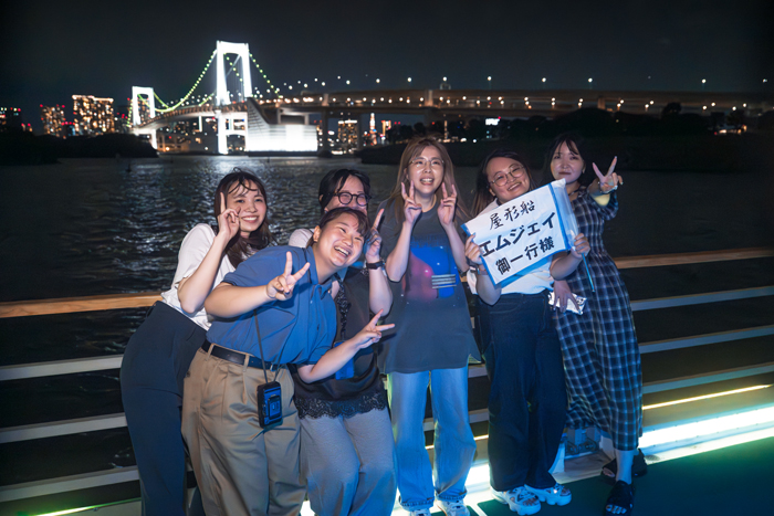 屋形船のデッキに出て景色を眺める参加者